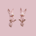 Geometric bunny stud earrings in blush pink and white with gold nose detail on a soft pink background