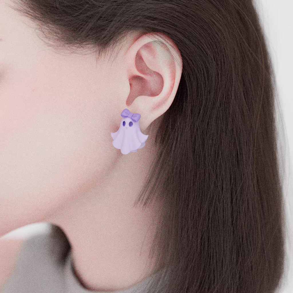 Pastel ghost earrings with lavender bow and witch hat details, handmade acrylic spooky cute jewelry on light purple background