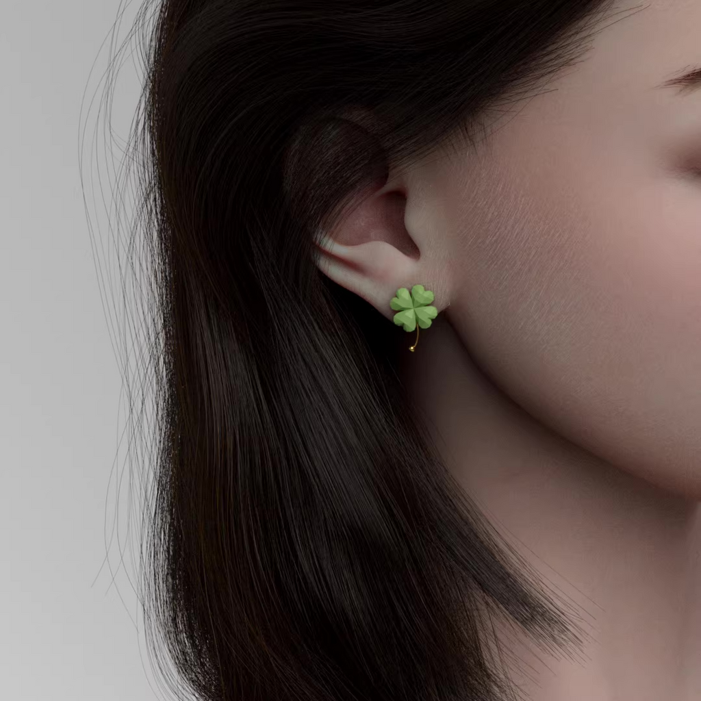 Green four-leaf clover drop earrings with gold accent, lightweight pastel jewelry on soft green background